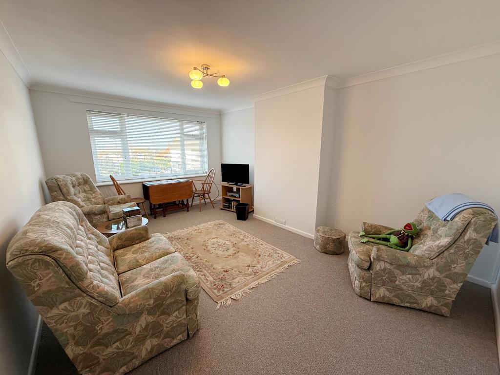 Lot: 1 - TWO-BEDROOM TOP FLOOR APARTMENT IN COASTAL LOCATION - Carpeted lounge with window